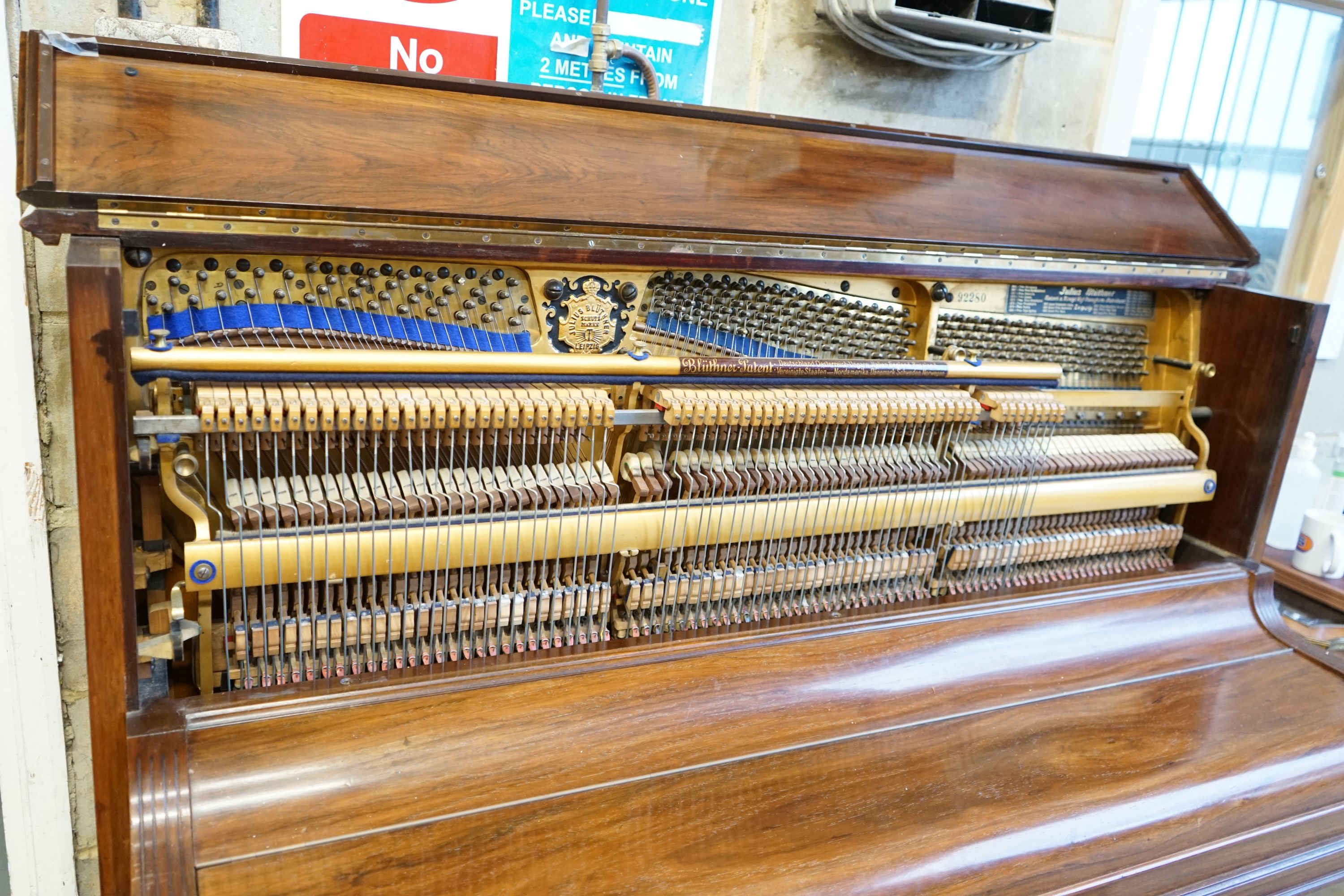 An early 20th century walnut cased Bluthner upright piano, Serial Number 92280